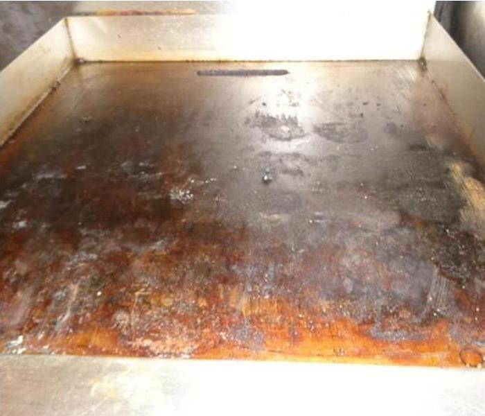Commercial stove covered in grease.