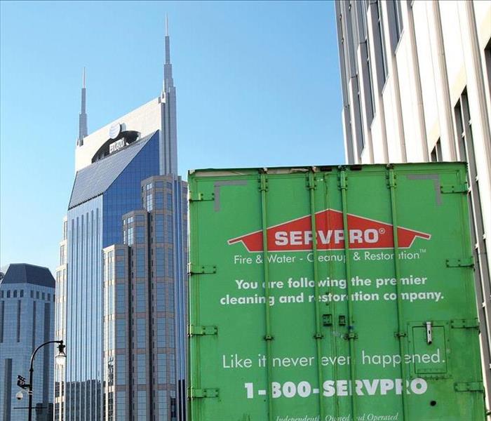 Green SERVPRO semi in front of commercial building.