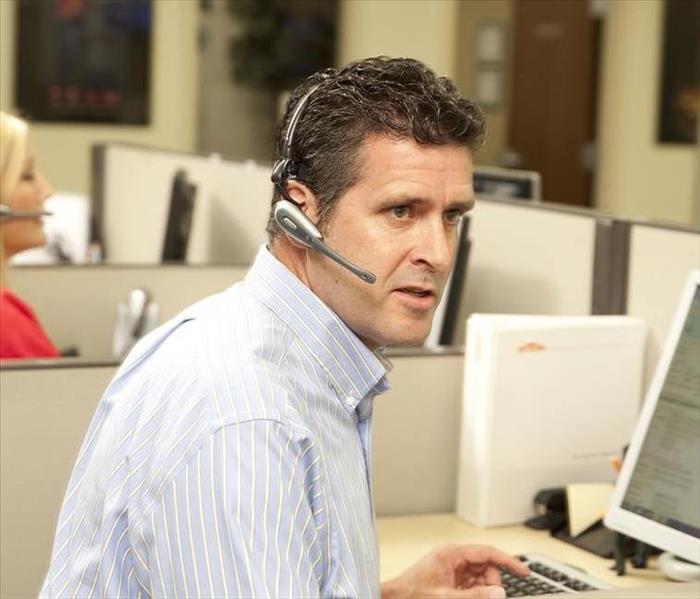 Man with phone head set speaking to a customer.
